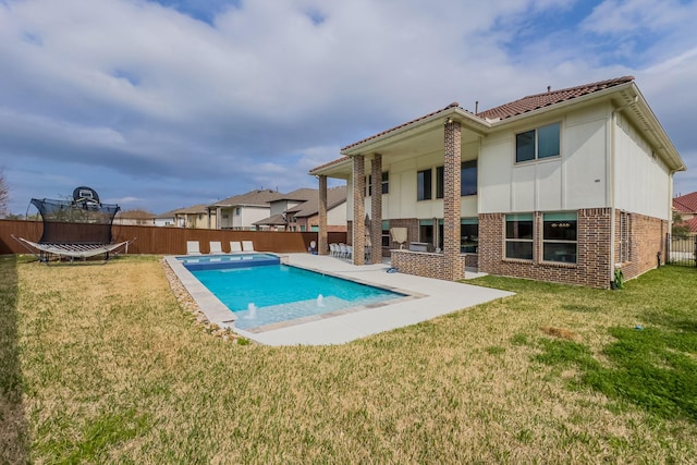 view of pool featuring a trampoline, a fenced backyard, and a lawn