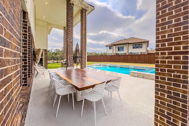 view of swimming pool with outdoor dining space, a fenced backyard, a fenced in pool, and a patio