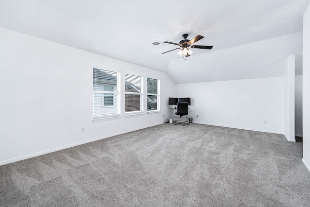 interior space featuring ceiling fan, visible vents, baseboards, vaulted ceiling, and carpet