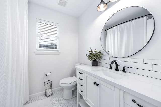 full bathroom featuring toilet, vanity, visible vents, baseboards, and backsplash