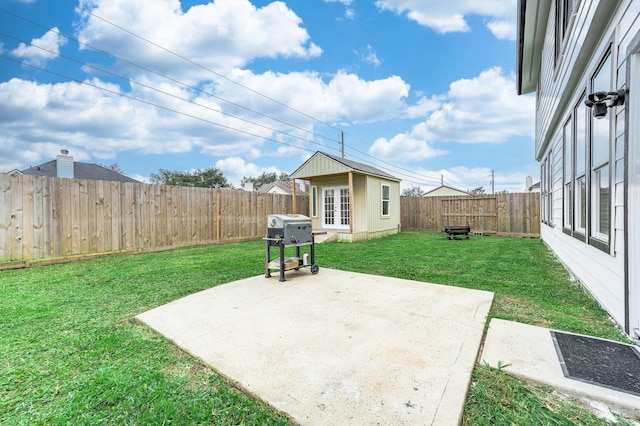 view of yard with an outbuilding, a fenced backyard, and a patio