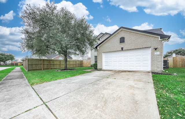 view of side of home featuring driveway, brick siding, a lawn, and fence