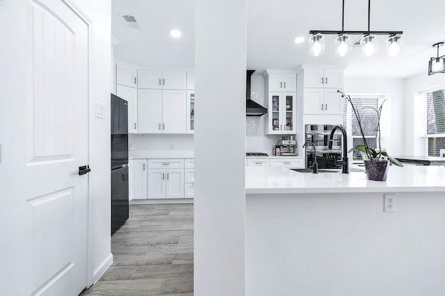 kitchen featuring white cabinets, visible vents, glass insert cabinets, and light countertops