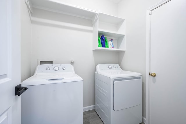 laundry room with washer and dryer, laundry area, baseboards, and wood finished floors