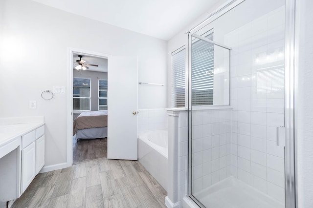 ensuite bathroom featuring a garden tub, ensuite bath, wood finished floors, and a stall shower