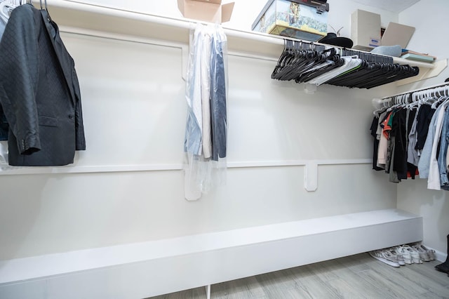 walk in closet with wood finished floors