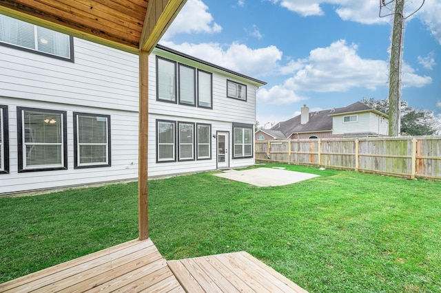 back of property featuring a yard, a patio area, fence, and a wooden deck