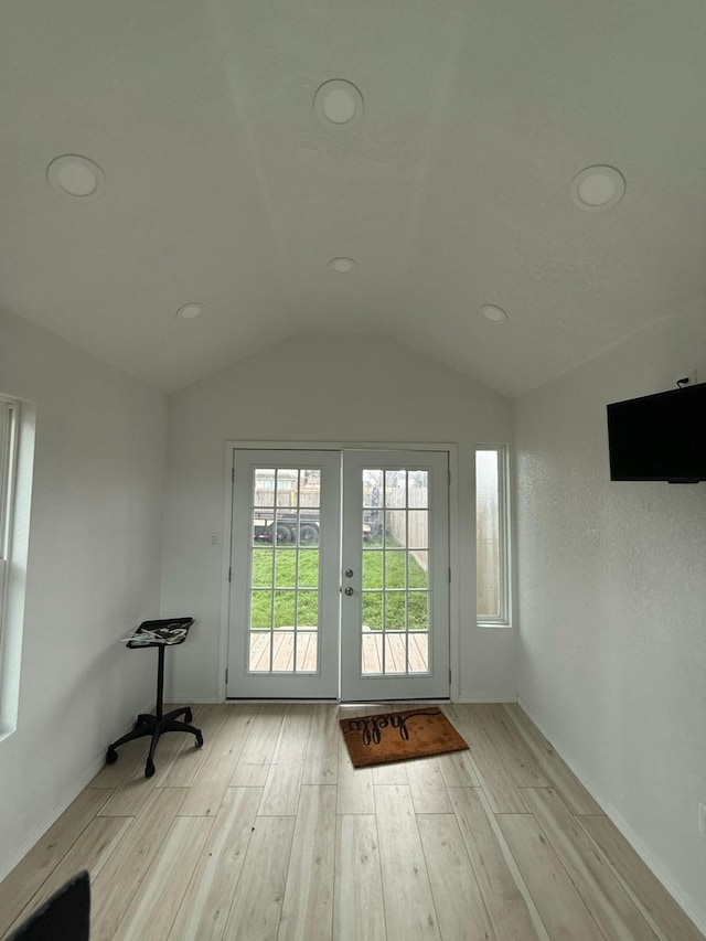 doorway to outside featuring vaulted ceiling, french doors, and light wood-type flooring