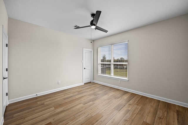 unfurnished room featuring a ceiling fan, baseboards, and wood finished floors