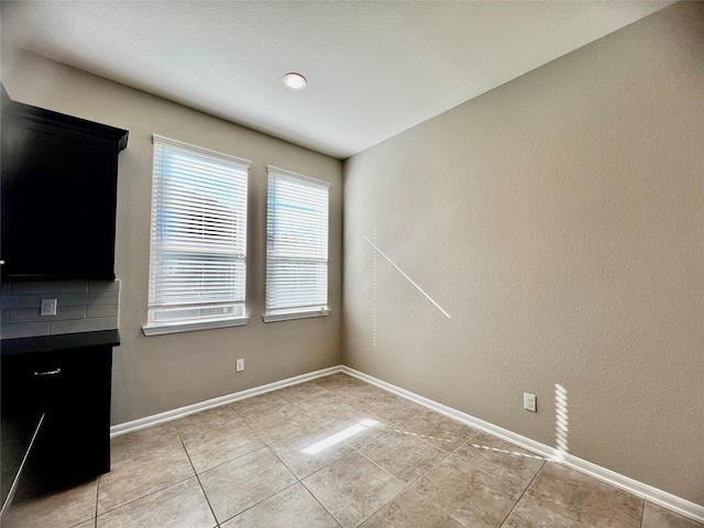 interior space with baseboards and light tile patterned floors