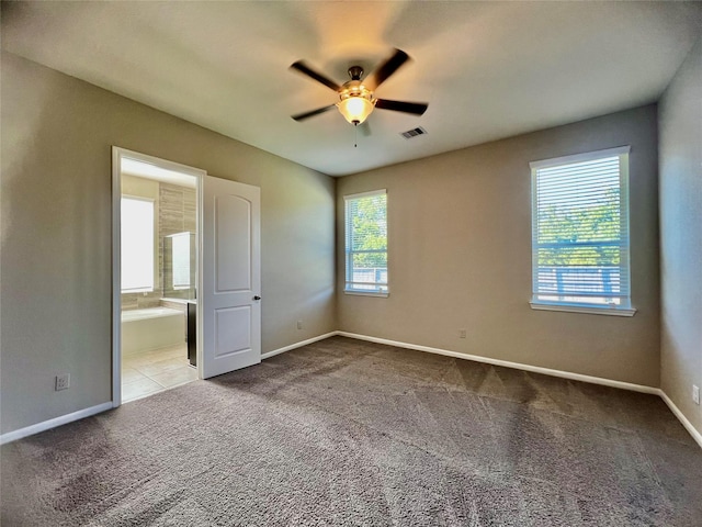 unfurnished bedroom featuring light carpet, baseboards, visible vents, and ensuite bathroom