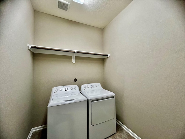 washroom featuring laundry area, baseboards, visible vents, and washing machine and clothes dryer