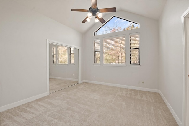 unfurnished room with light carpet, ceiling fan, baseboards, and lofted ceiling