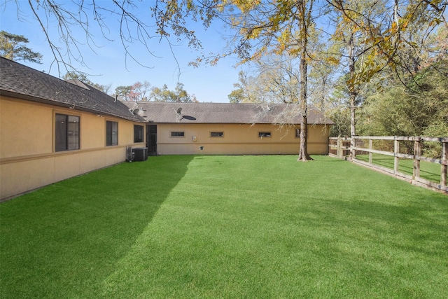 view of yard featuring central air condition unit and fence