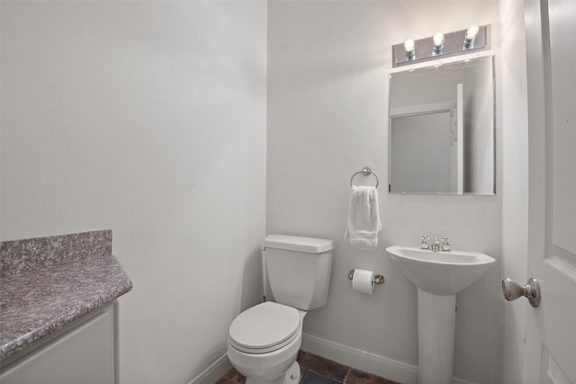 bathroom with toilet and baseboards