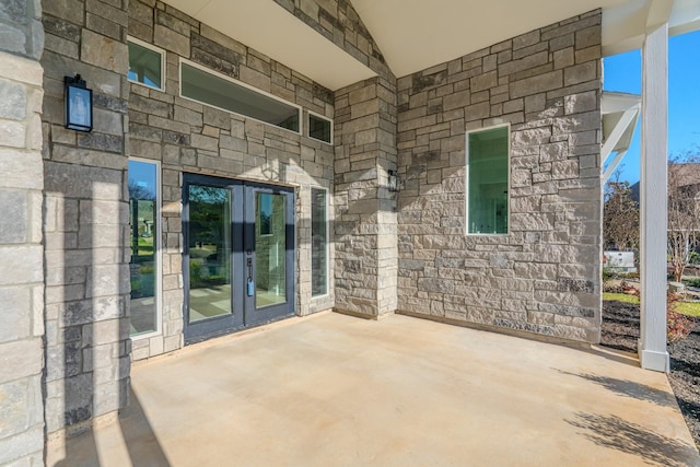 exterior space with stone siding, french doors, and a patio area