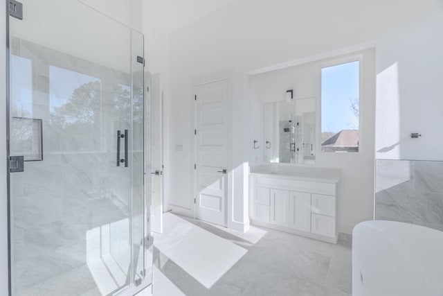 bathroom featuring a freestanding bath, a stall shower, and vanity