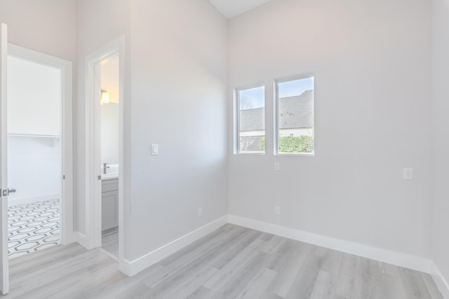 empty room with light wood-type flooring and baseboards