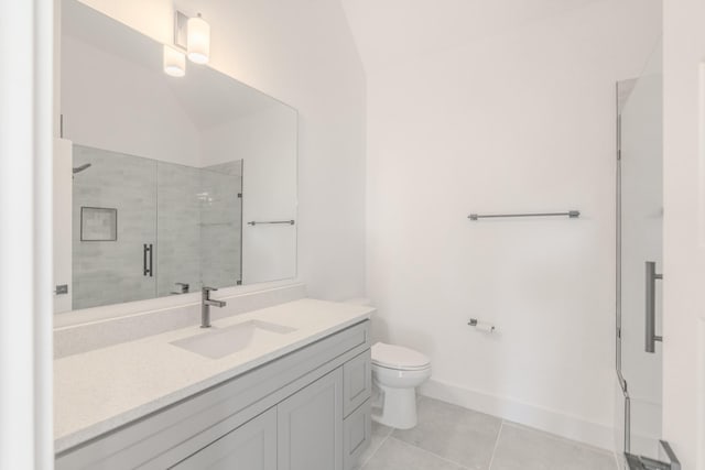 bathroom with a stall shower, baseboards, toilet, tile patterned flooring, and vanity