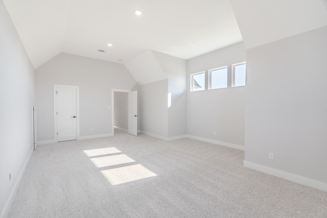 additional living space featuring vaulted ceiling, recessed lighting, baseboards, and light colored carpet