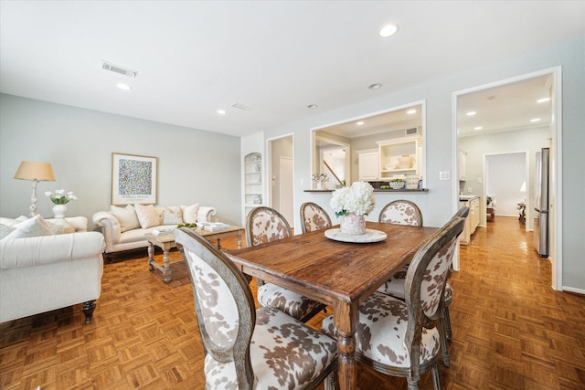 dining area with built in features, visible vents, and recessed lighting