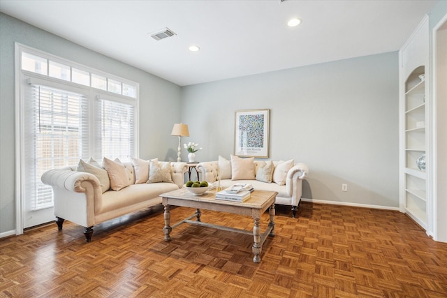 living area with baseboards, visible vents, and recessed lighting