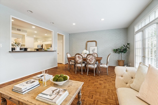 dining space with recessed lighting, visible vents, and brick wall