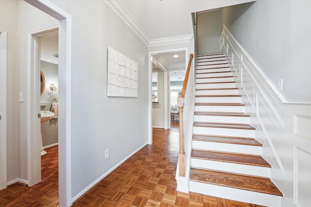 stairway with ornamental molding and baseboards