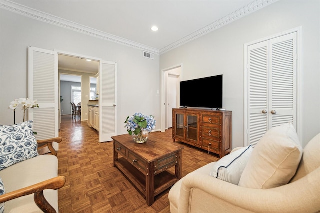 living room with recessed lighting, visible vents, and crown molding