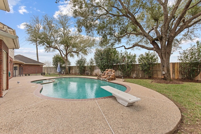 view of pool featuring a patio area, a fenced backyard, a pool with connected hot tub, and a diving board