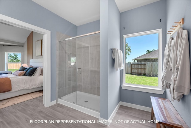 ensuite bathroom featuring ensuite bathroom, wood finished floors, a shower stall, and baseboards