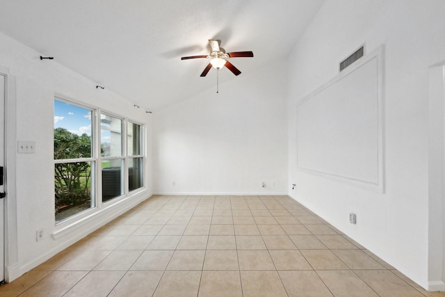 empty room featuring lofted ceiling, ceiling fan, light tile patterned floors, visible vents, and baseboards