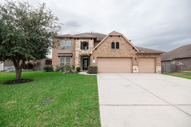 view of front of home with an attached garage, brick siding, fence, concrete driveway, and a front yard