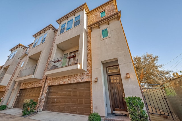 view of front of house featuring an attached garage, concrete driveway, and stucco siding