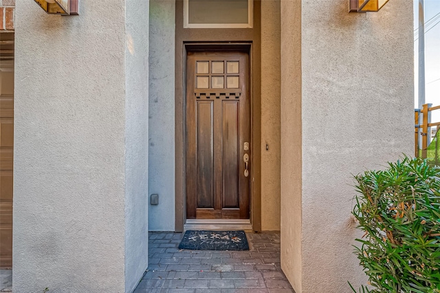 view of exterior entry with stucco siding