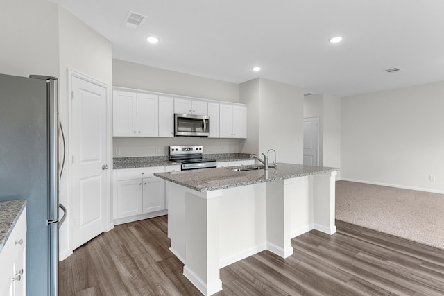 kitchen featuring appliances with stainless steel finishes, white cabinetry, a center island with sink, and a sink