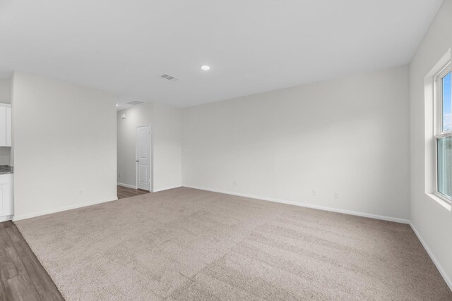 unfurnished room featuring baseboards, visible vents, dark colored carpet, and recessed lighting