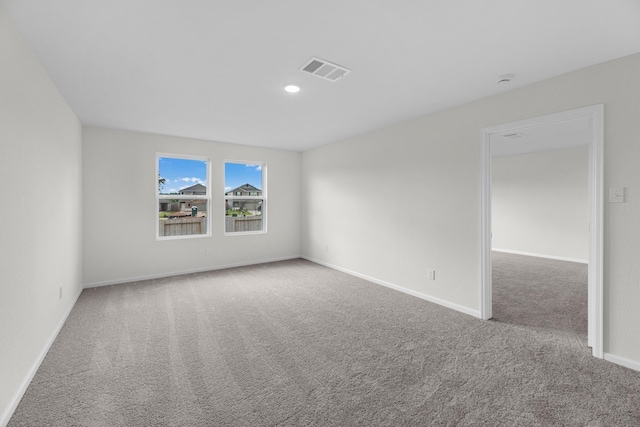 spare room with light colored carpet, visible vents, baseboards, and recessed lighting