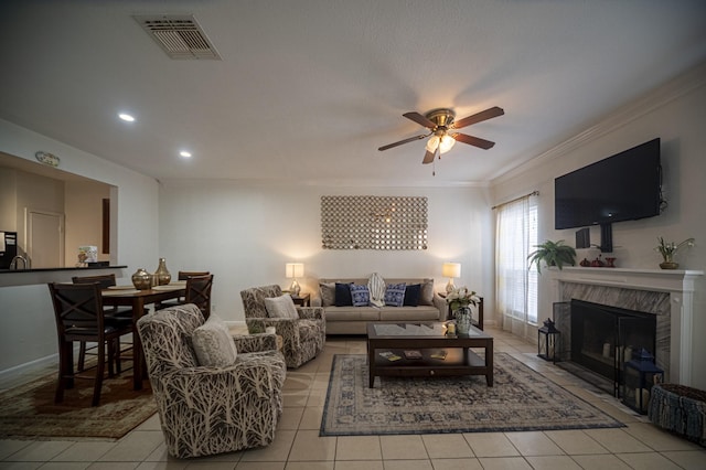 living area with light tile patterned floors, visible vents, and crown molding