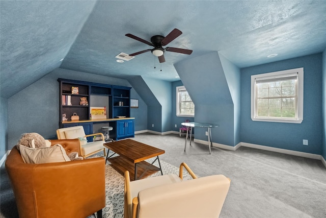 sitting room featuring a textured ceiling, baseboards, visible vents, and light colored carpet