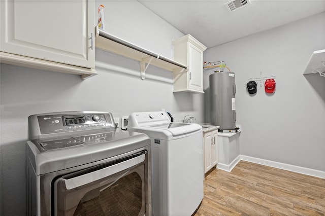 clothes washing area featuring cabinet space, visible vents, light wood-style flooring, washing machine and dryer, and electric water heater