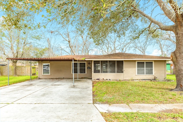 ranch-style home with a carport, driveway, a front lawn, and fence