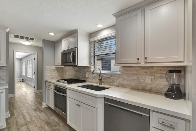 12203 W Morgan Dr, Houston, TX 77065 - kitchen featuring visible vents, light countertops, decorative backsplash, appliances with stainless steel finishes, and a sink
