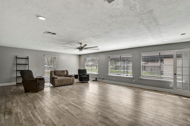 12203 W Morgan Dr, Houston, TX 77065 - unfurnished living room with a ceiling fan, wood finished floors, visible vents, and a healthy amount of sunlight