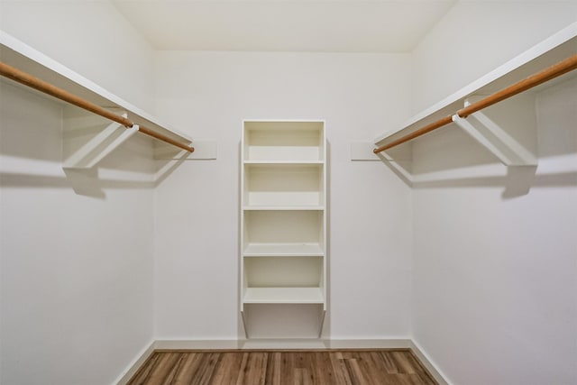 walk in closet with wood finished floors