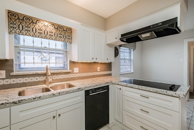 kitchen with tasteful backsplash, under cabinet range hood, black appliances, white cabinetry, and a sink