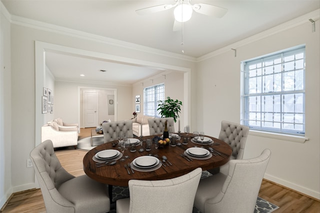 dining room featuring baseboards, crown molding, light wood finished floors, and ceiling fan