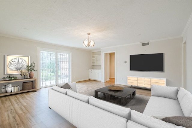 living room with light wood finished floors, visible vents, ornamental molding, a textured ceiling, and a chandelier