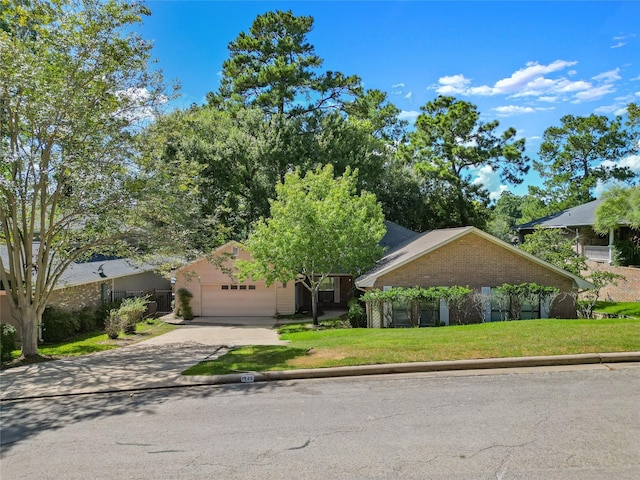 view of front of house with a garage, concrete driveway, brick siding, and a front yard