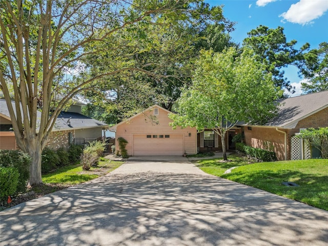 view of front of house with a garage, driveway, fence, and a front lawn